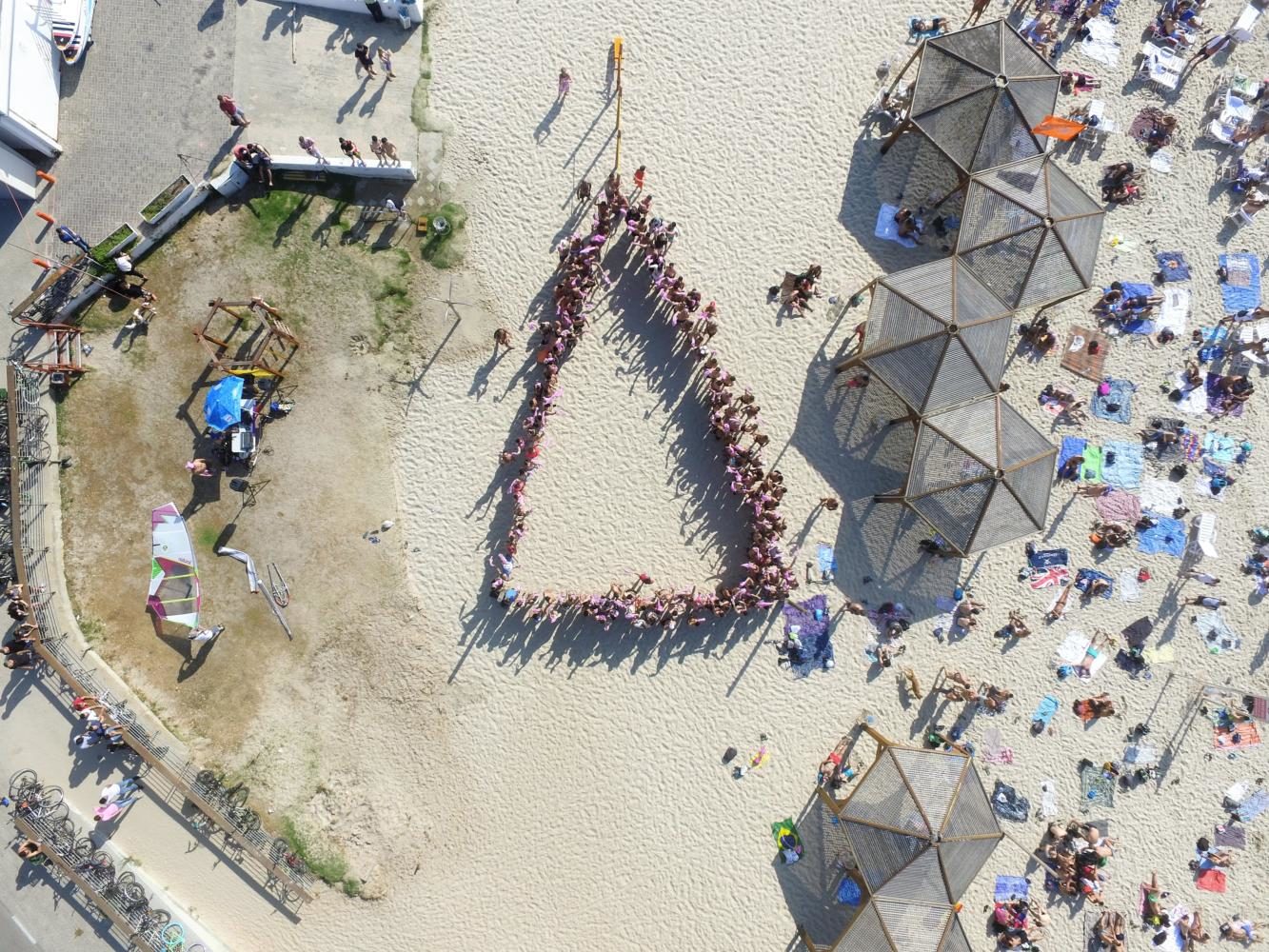 Beachgoers form a pink triangle at the Hilton Beach to show their support for the gay men in Chechnya.  The pink triangle was first used by Hitler to identify gay men during the Holocaust. 