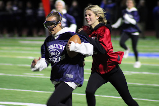 Blue running-back Paige Comer running the ball past Cornerback Grace Statchuk.