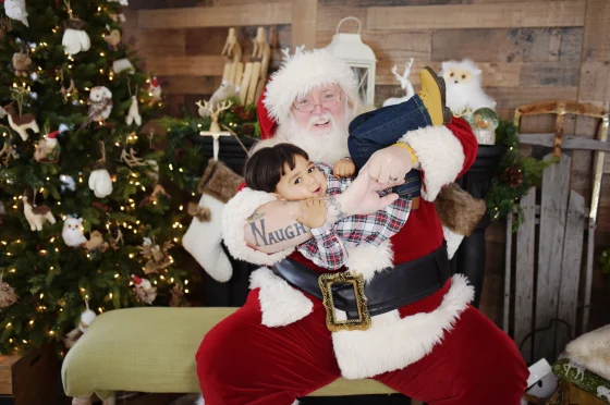 Santa Scott, posing for a photo with a child in photographer Allicia Leaper’s studio. (Crush Photography Studios/Allicia Leaper)